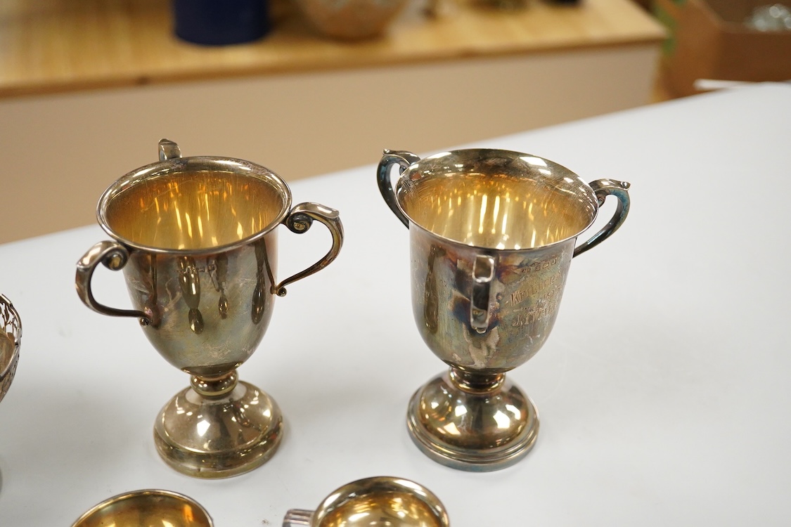 Five assorted George V silver trophy cups including two tri-handled, approx. 12.2cm and a silver bon-bon dish, with pierced border, 19.3oz.